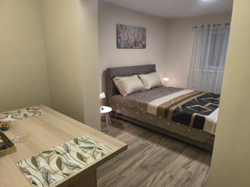 a small bedroom with a bed and a table at Ketty apartments in Niš