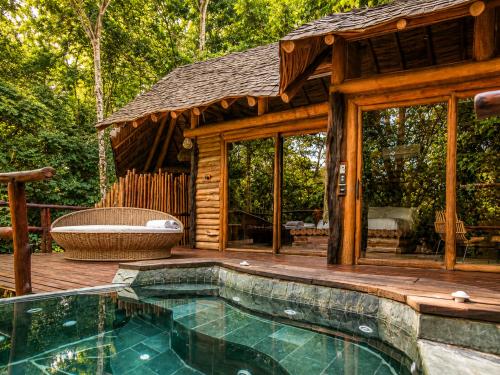 a log cabin with a swimming pool and a deck at Hotel Boutique Maitta en Doradal Antioquia in Doradal