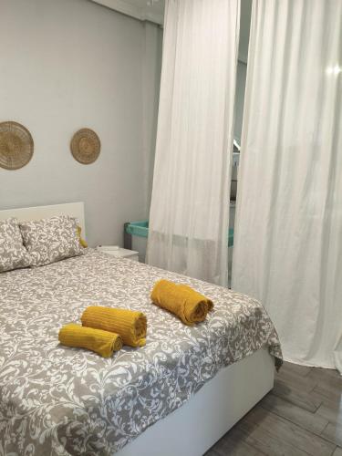two yellow pillows on a bed in a bedroom at El Molar Loft in El Molar