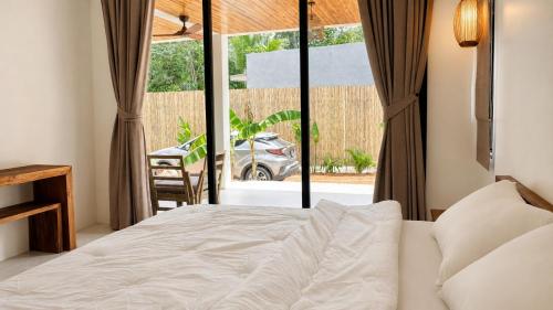 a bedroom with a bed and a large window at Maprao Tropical Home in Ko Phangan