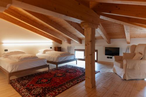 a bedroom with two beds and a couch and a tv at B&B Piccolo Relais in Lessolo