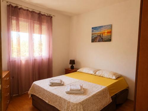 a bedroom with two beds and a window at Bgd apartman in Kavač