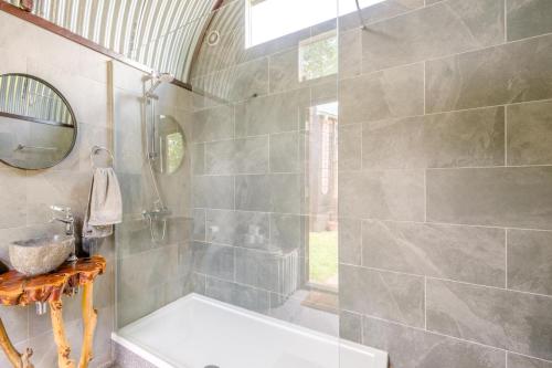 a bathroom with a shower with a tub and a sink at 1 Bed in Elsing oc-d44228 in Elsing