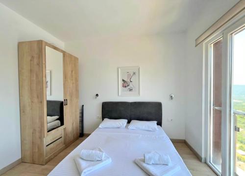 a bedroom with a large bed with a mirror at Cosy Adriatic Studio in Kotor