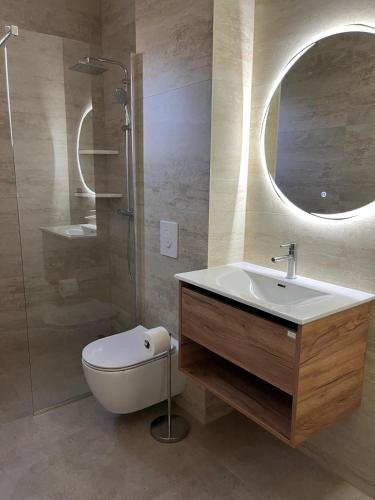 a bathroom with a sink and a toilet and a mirror at Apartmani KIKO in Međugorje