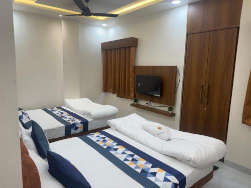 a hotel room with two beds and a tv at Hotel G17 Dhamnod in Dhāmnod