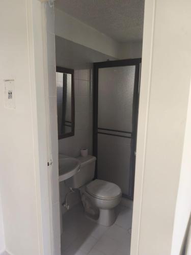 a small bathroom with a toilet and a sink at Villas del Oasis in Ricaurte