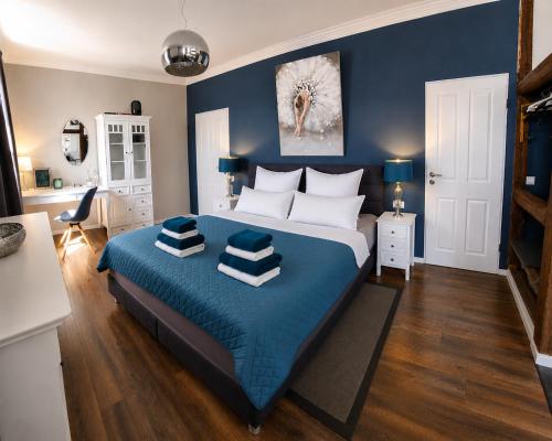 a bedroom with a large bed with blue walls at Apartmenthaus am See - Seeblick Suite - Nähe Motorsportarena in Seehausen