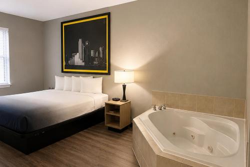 a hotel room with a bed and a bath tub at Super 8 by Wyndham Brenham TX in Brenham