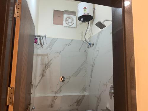 a bathroom with a marble shower with a toilet at Hotel G17 Dhamnod in Dhāmnod