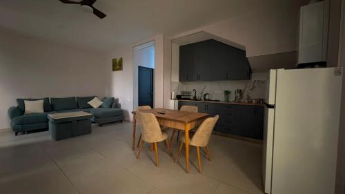 a kitchen and living room with a table and a refrigerator at Pine villa sadgeri in Sadgeri