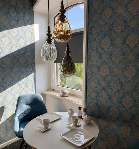 a table and a blue chair and a window at Apartmenthaus am See - Seeblick Suite - Nähe Motorsportarena in Seehausen