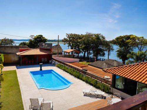 a swimming pool in a yard next to a house at Pousada Recanto das Águas - Fama MG in Fama