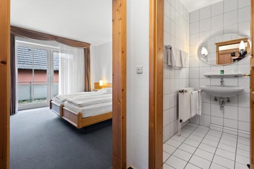 a bathroom with a bed and a sink in a room at Landgasthaus Fischer in Bad Nenndorf