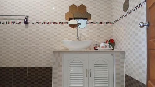a bathroom with a sink and a bowl on a cabinet at Romantic Vang Vieng resort in Vang Vieng