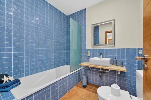 a blue tiled bathroom with a sink and a toilet at Luna in San Blas in San Miguel de Abona