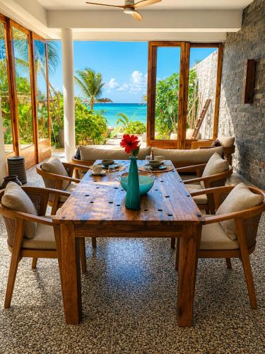 a dining room with a table and chairs and the ocean at Villa Duara Zanzibar Rooftop Infinity Pool The Rock View in Michamvi
