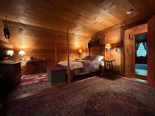 a bedroom with a bed in a wooden cabin at Old Deerfield Treasure! in Deerfield