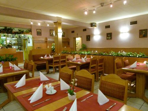 ein Restaurant mit Tischen und Stühlen mit Servietten darauf in der Unterkunft Hotel Pelikan in Marienbad