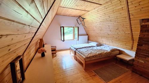 an attic bedroom with a bed and a window at Chata uprostred lesa Modrová in Modrová