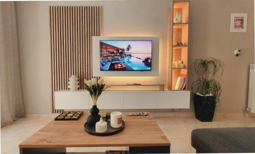 a living room with a tv on a wall at Maison Centrale - Free Private Parking - Luxury Stay in Serres Center in Serres