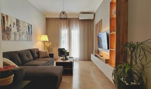 a living room with a couch and a tv at Maison Centrale - Free Private Parking - Luxury Stay in Serres Center in Serres