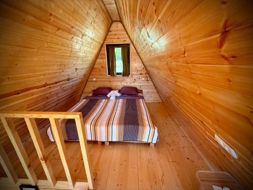 a room with a bed in a wooden cabin at Asureti Horizon Cottage in Asuretʼi