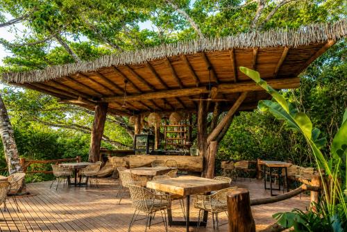 a wooden pergola with tables and chairs on a patio at Hotel Boutique Maitta en Doradal Antioquia in Doradal
