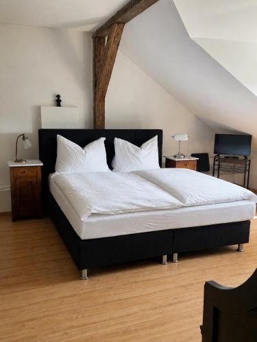 a bedroom with a bed with white sheets and pillows at Apartmán Bonaparte in Loket