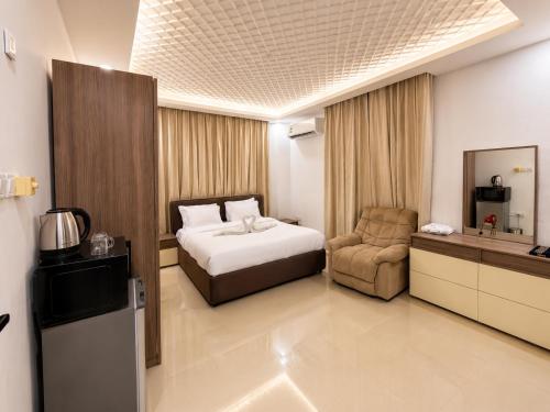 a hotel room with a bed and a chair at Albazar Residence Salalah in Salalah