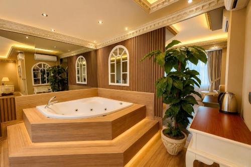 a large bathroom with a tub and a plant at REAL KiNG RESiDENCE in Trabzon