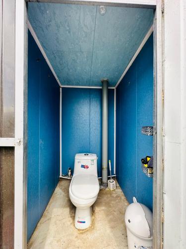 a bathroom with a toilet in a blue wall at Aspan Kazakh Ger Camp in Ölgiy