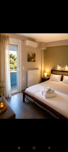 a bedroom with a large bed and a window at Vasiliki apartment in Kalamata