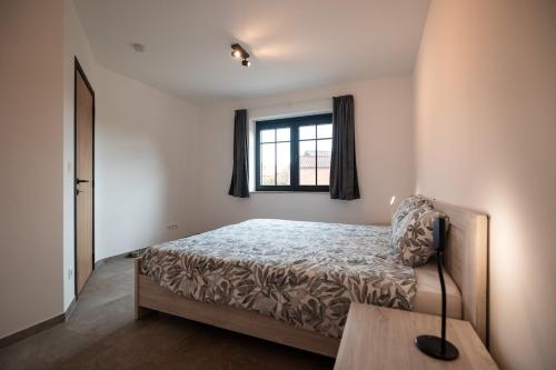 a bedroom with a bed and a window at Horse Valley in Tongeren