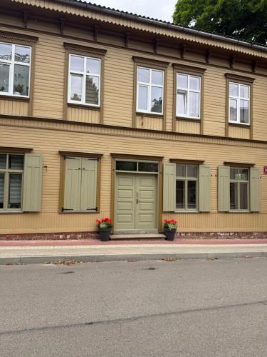 a building with green doors and windows on a street at Parka ielas apartamenti in Limbaži