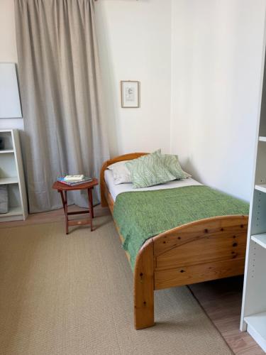 a bedroom with a wooden bed and a table at Lorenzo Apartments 05 in Burglengenfeld