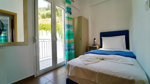 a bedroom with a bed and a large window at Mediterraneo Resort in Parga