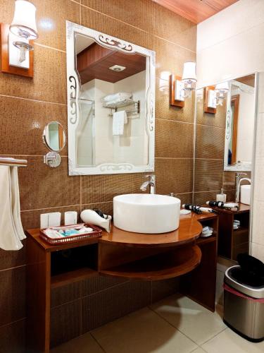 a bathroom with a sink and a mirror at Basra Touristic Hotel in Al Başrah