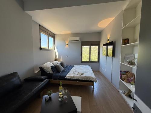 a small room with a bed and a couch at Autarke Ökovilla in Agios Myronas
