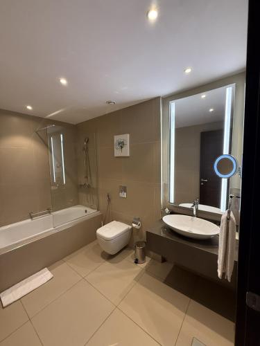 a bathroom with a sink and a toilet and a tub at Residence Inn by Marriott Algiers Bab Ezzouar in Alger