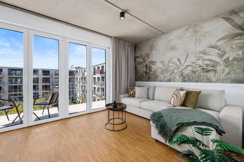 a living room with a couch and a balcony at Svyvo Cologne - Serviced Apartments Ehrenfeld in Cologne
