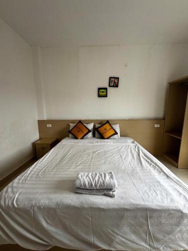 a large white bed with a pillow on it at Vang Vieng Ha Ha Hotel in Vang Vieng