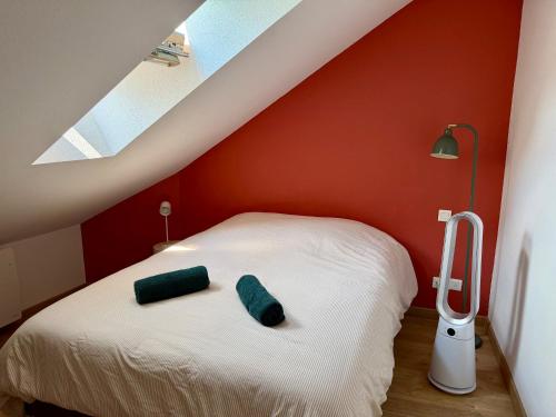 a bedroom with a bed with green pillows on it at Le charmant Duplex de la Bibliothèque - Vélos Friendly- Centre historique et proche Europa-Park in Sélestat