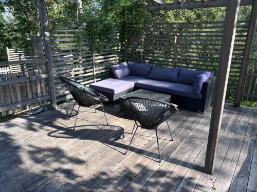 a patio with a couch and two chairs and a table at The Archipelago Hideaway in Vaxholm