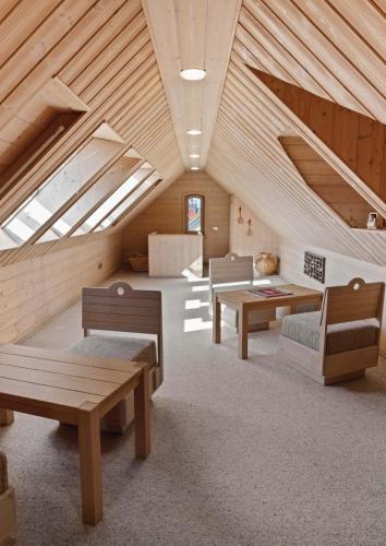 a room with benches and tables in a attic at Residence KESH in Krumbach