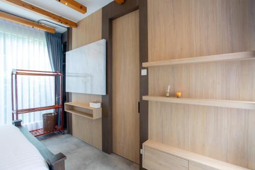 a room with wooden walls and a screen on the wall at Sawasdee pool villa, Hua Hin in Hua Hin