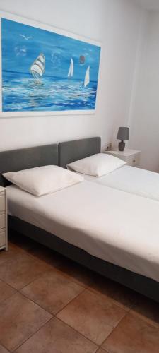 a bedroom with a bed with a painting on the wall at studio in garden in Poros