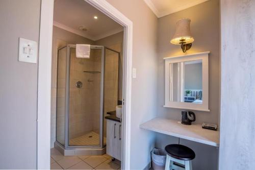 a bathroom with a shower and a sink and a mirror at The woods at Eleven in White River