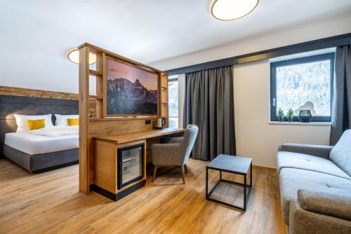 a hotel room with a bed and a living room at Aparthotel Fuxbau in Flachau