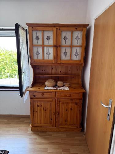 ein Holzschrank in einem Zimmer mit Fenster in der Unterkunft Casa Prisca in Bellinzona